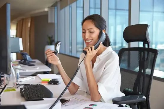 Femme souriante au téléphone dans un bureau moderne
