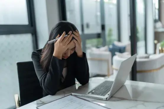 Femme stressée devant son ordinateur face à une facture impayée