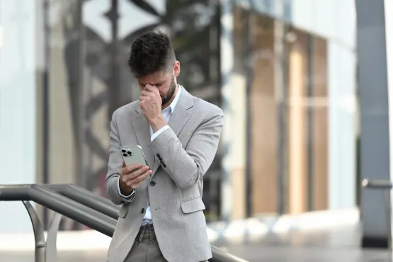 Homme inquiet lisant une facture sur son téléphone
