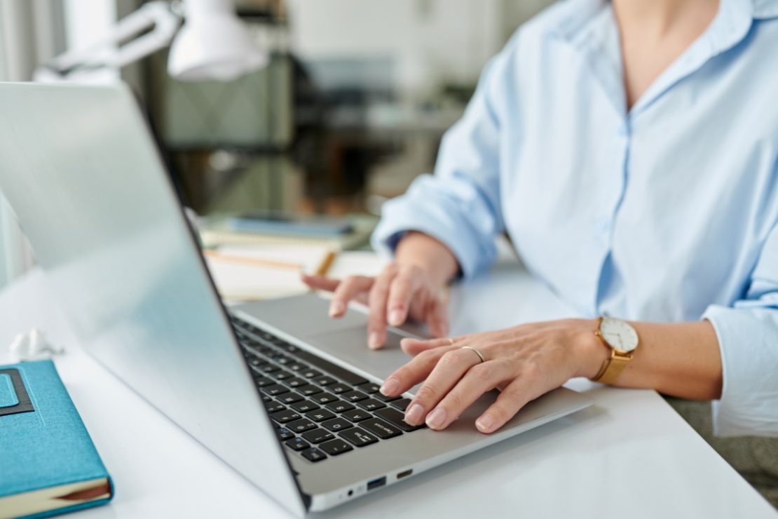 une femme tape sur son clavier pour effectuer un envoi de documents confidentiels par piece jointe sur un ordinateur