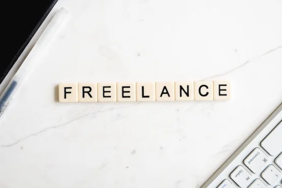 Vue du mot "FREELANCE" écrit avec des lettres de scrabble sur un bureau