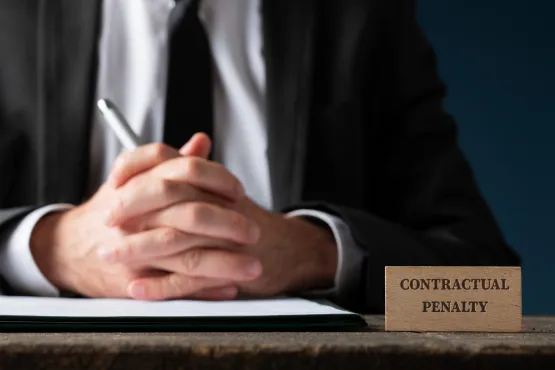Homme en costume devant un panneau indiquant "Contractual Penalty"