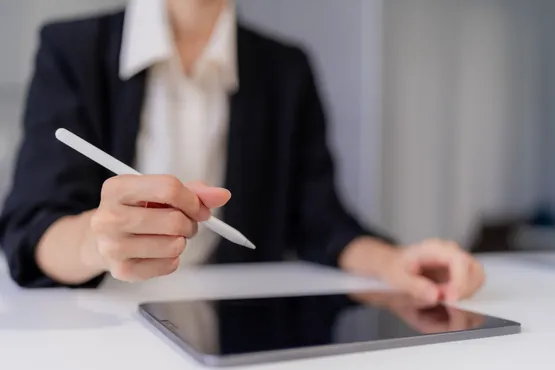 Femme signant un document numérique à l’aide d’un stylet et d’une tablette